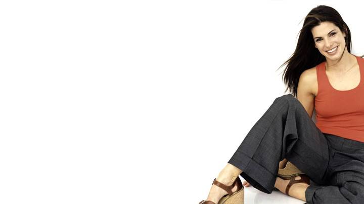 Sandra Bullock Smiling In Red Top N Black Trouser Sitting Pose